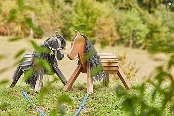 Zwei Holzpferde im Grünen als Spielmöglichkeit für Kinder